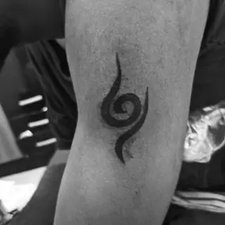 Símbolo espiral da Anbu, de Naruto, tatuado no braço