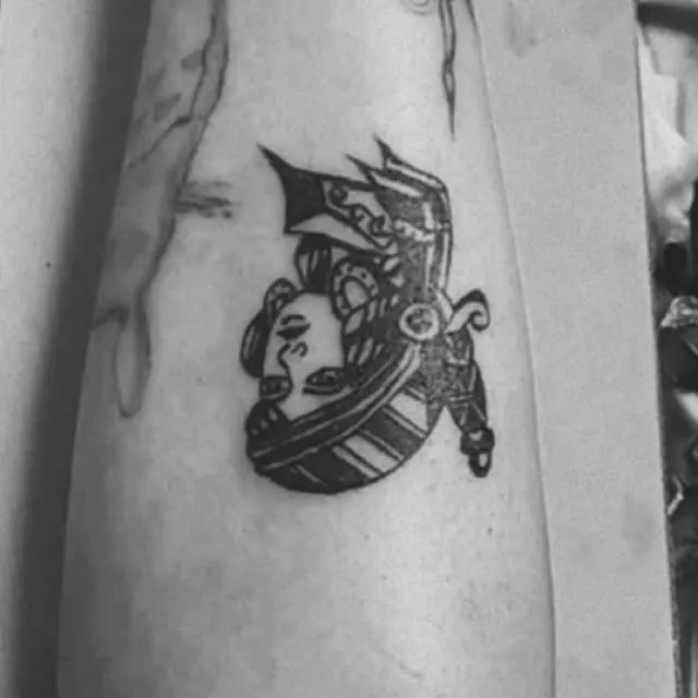 Gueixa com adorno no cabelo, tatuagem old school em preto no antebraço