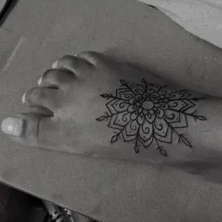 Mandala delicada tatuada no peito do pé
